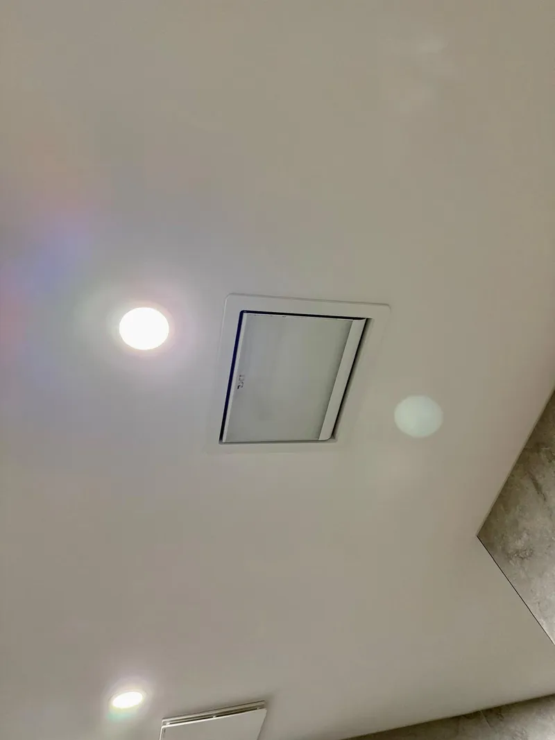 Bathroom ceiling with a downlight and a square ceiling vent