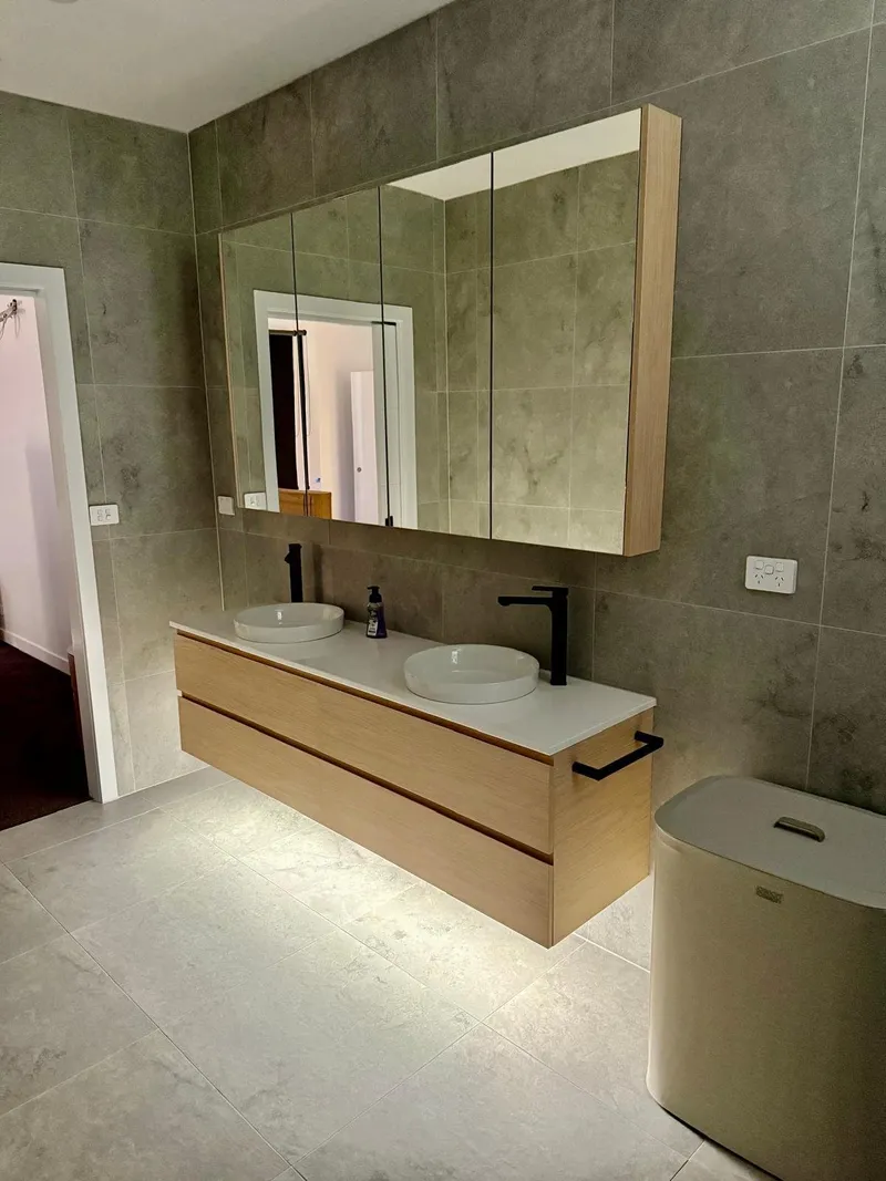 Double vanity with LED strip lighting underneath and a wide mirror cabinet above