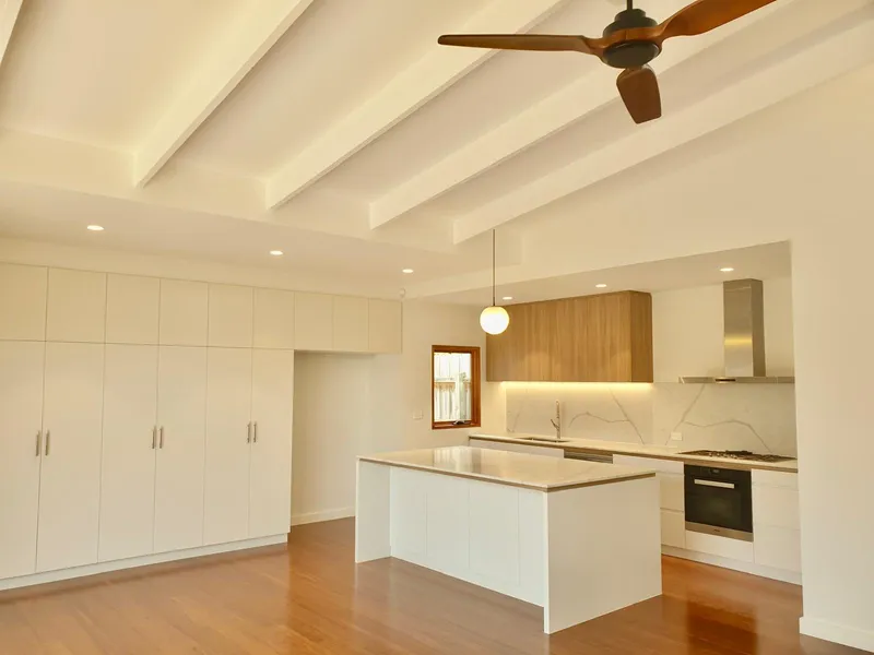 Renovated kitchen with exposed ceiling beams, a timber ceiling fan, a pendant light and downlights