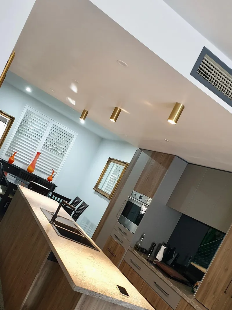 Kitchen with gold cylinder downlights above the island benchtop