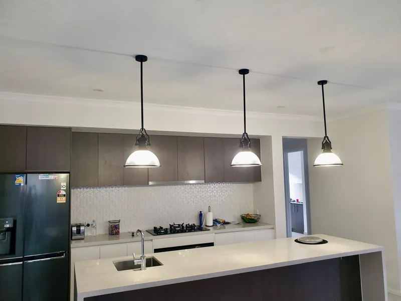 Kitchen island with three pendant lights hanging above the benchtop