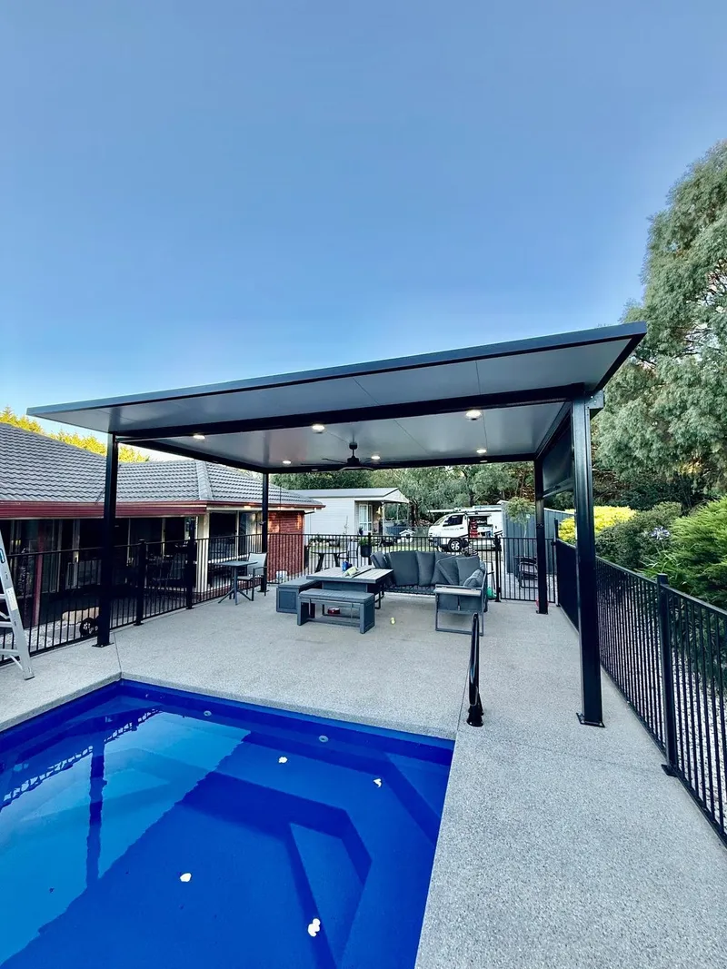 Backyard pool with an outdoor pavilion fitted with downlights and a ceiling fan
