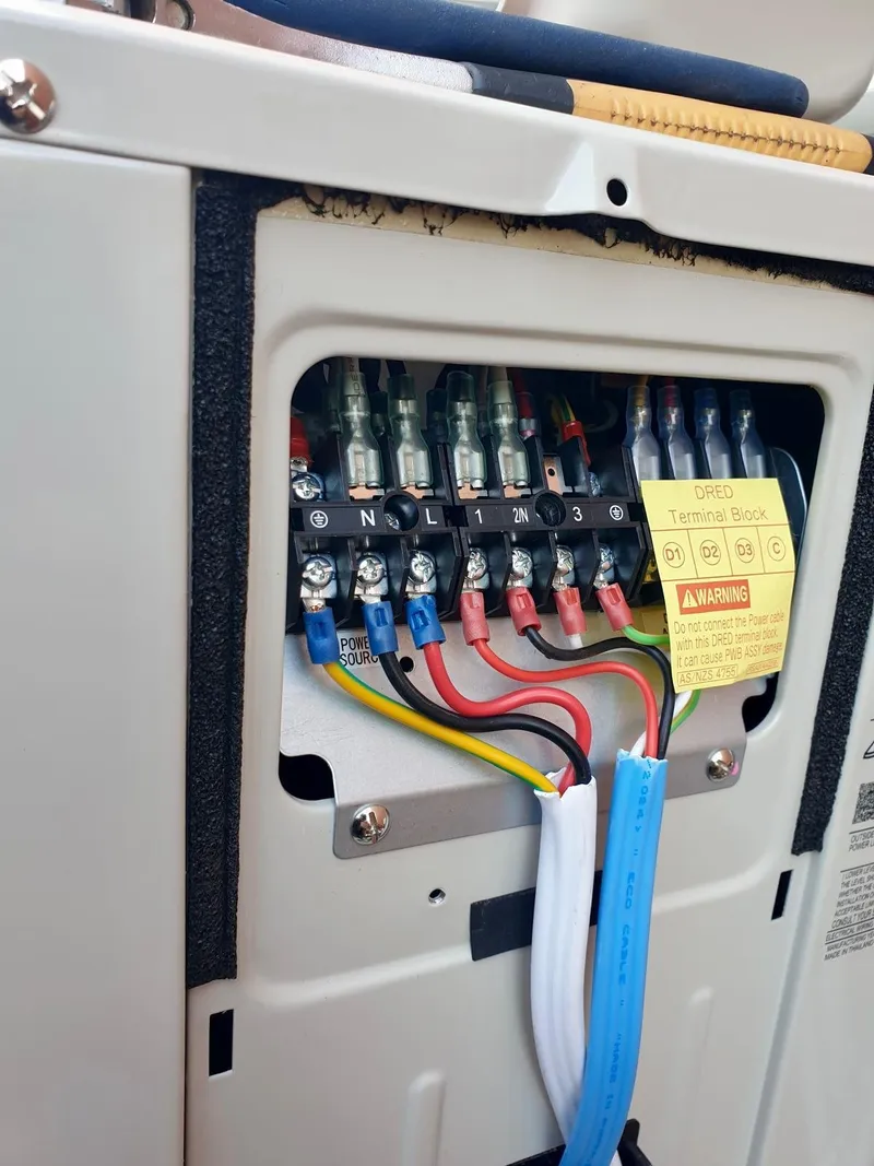 Wiring terminals inside an outdoor unit, including a labelled DRED terminal block