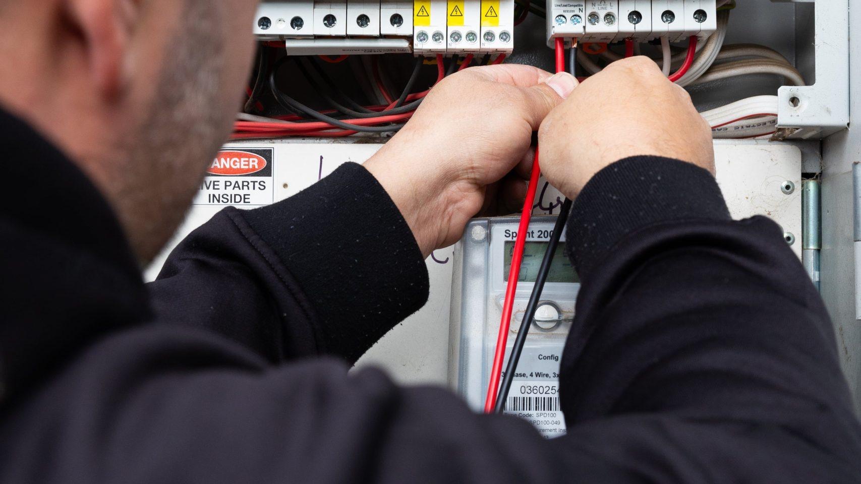 Yiannis testing at a Melbourne switchboard, meter and circuit breakers exposed