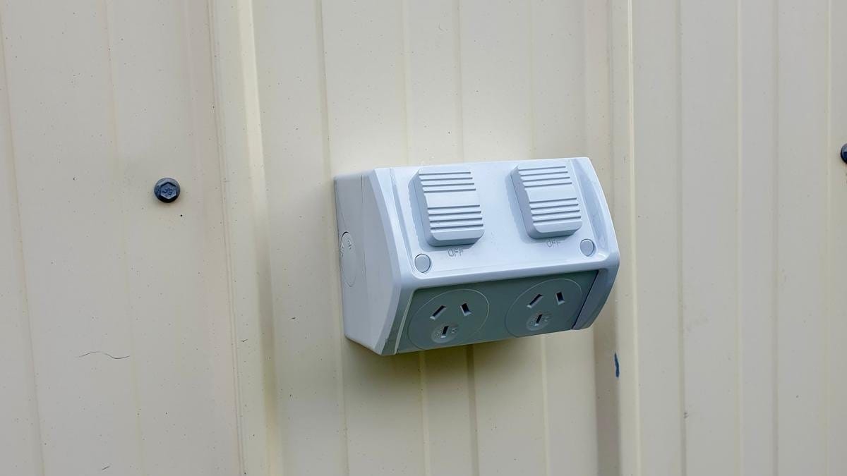 Weatherproof double power point on a cream steel wall