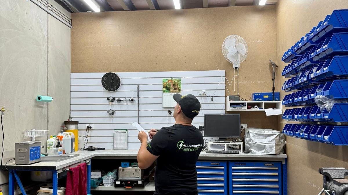 Yiannis in a fitted-out service workshop lit by LED battens