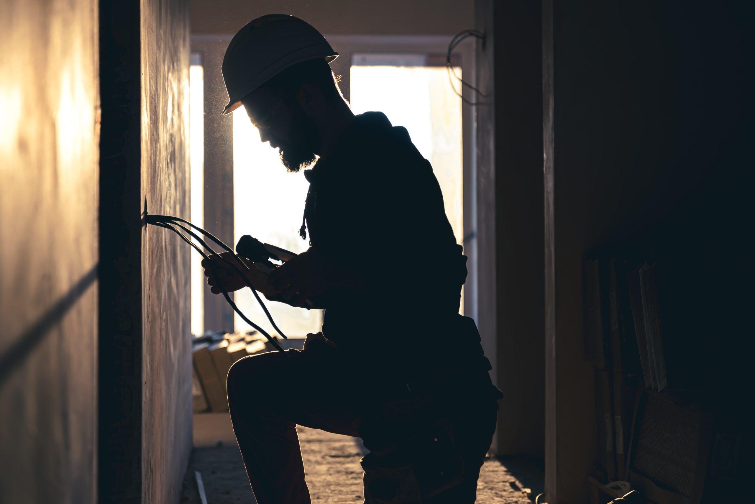 Electrician installing wiring in a Melbourne home at sunset